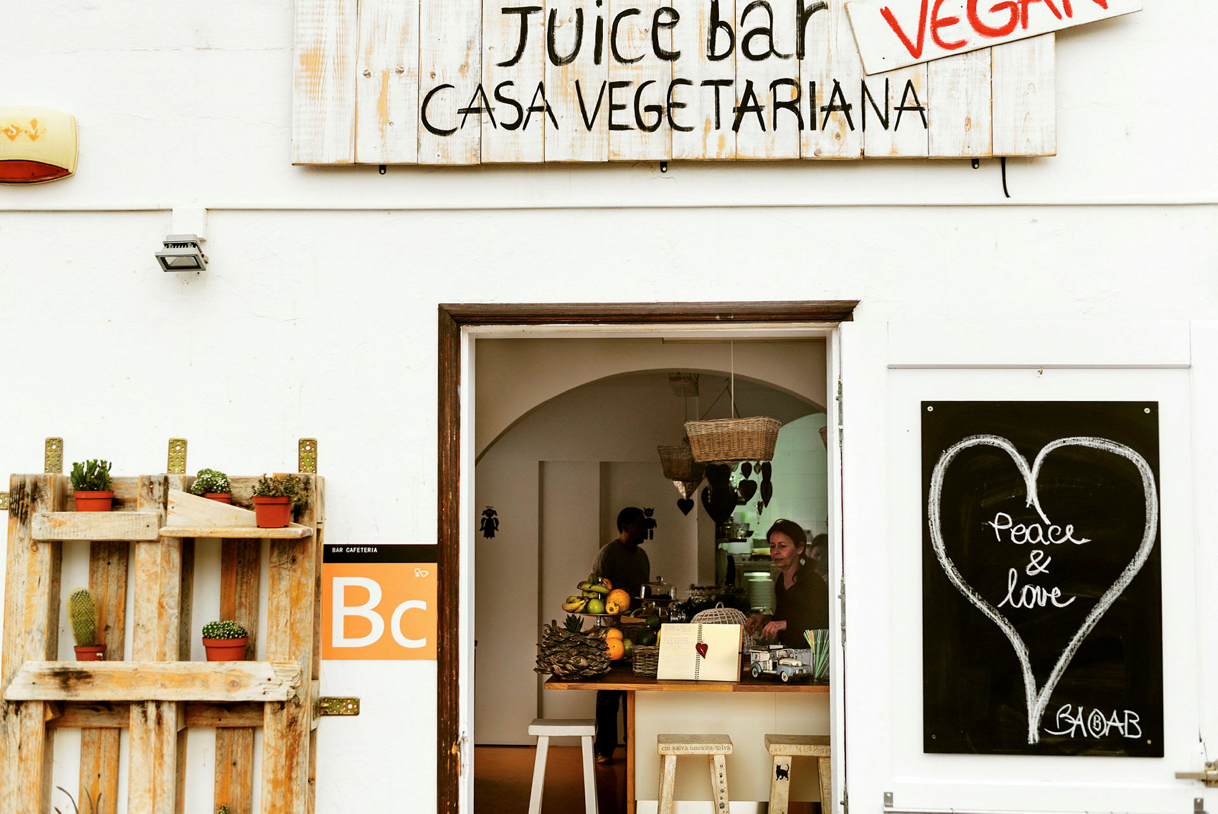 Indgang til en juicebar med skilte og dekorationer. (AI-genereret tekst)