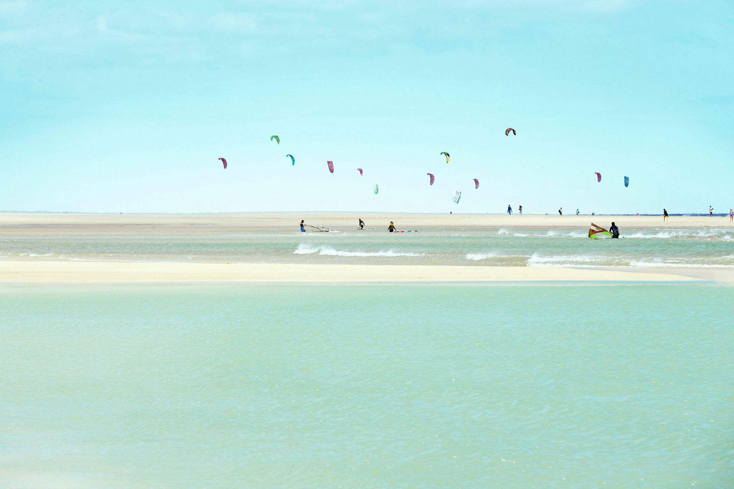 Strand med folk, der kitesurfer. (AI-genereret tekst)