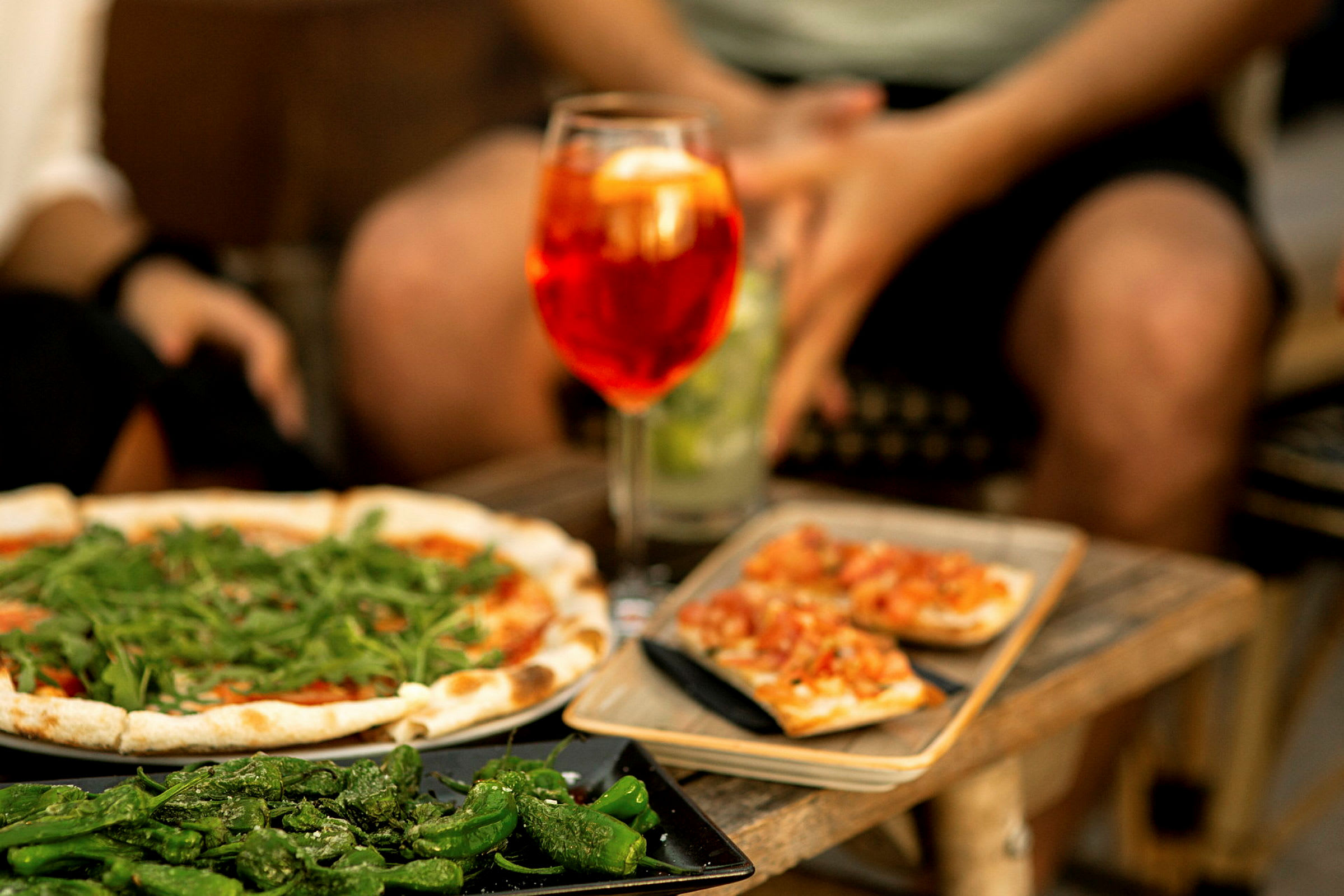 En fremvisning af pizza, grillede peberfrugter og bruschetta serveret med en drink. (AI-genereret tekst)