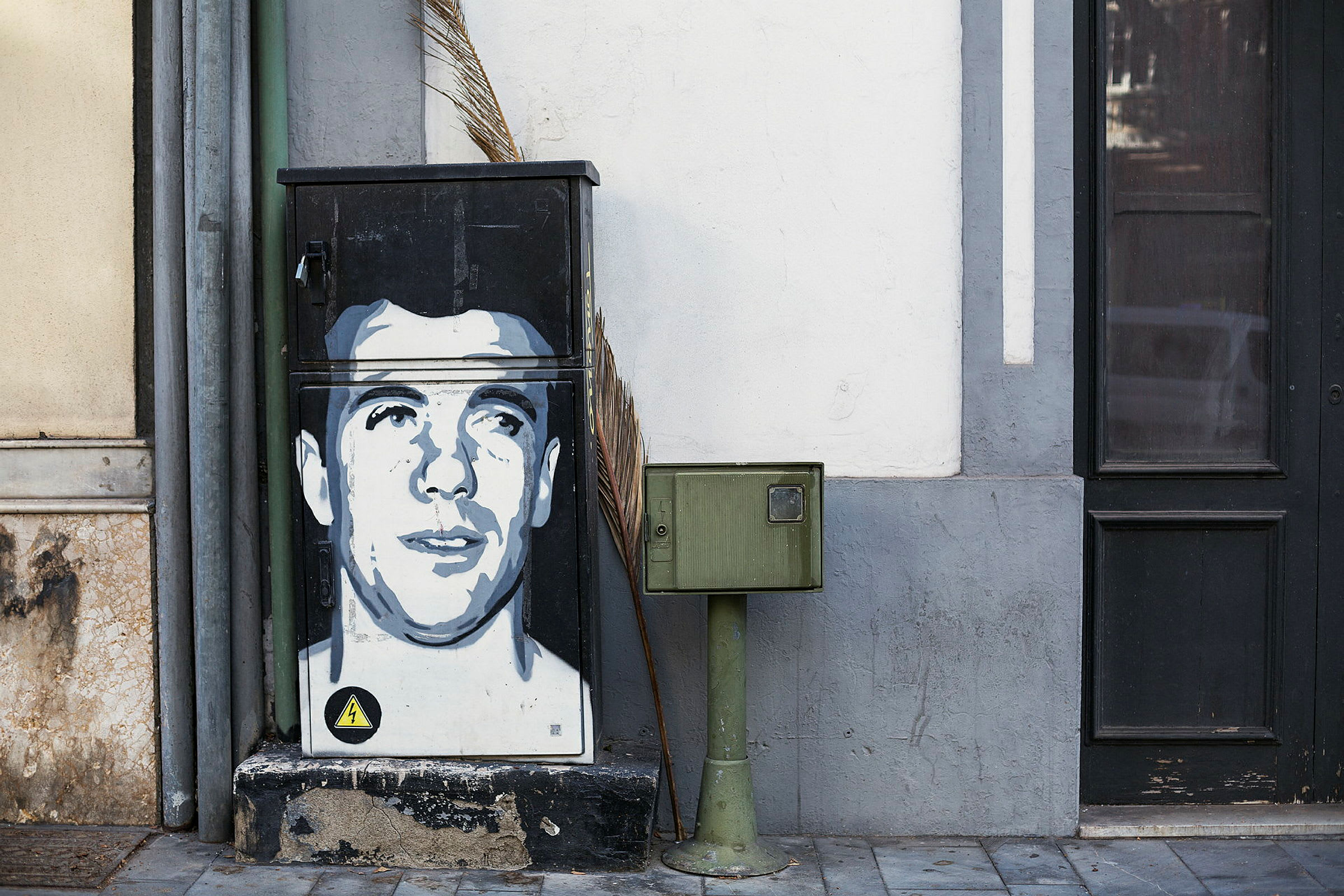 Et elektrisk skab med graffiti ved siden af en brevkassetolpe. (AI-genereret tekst)
