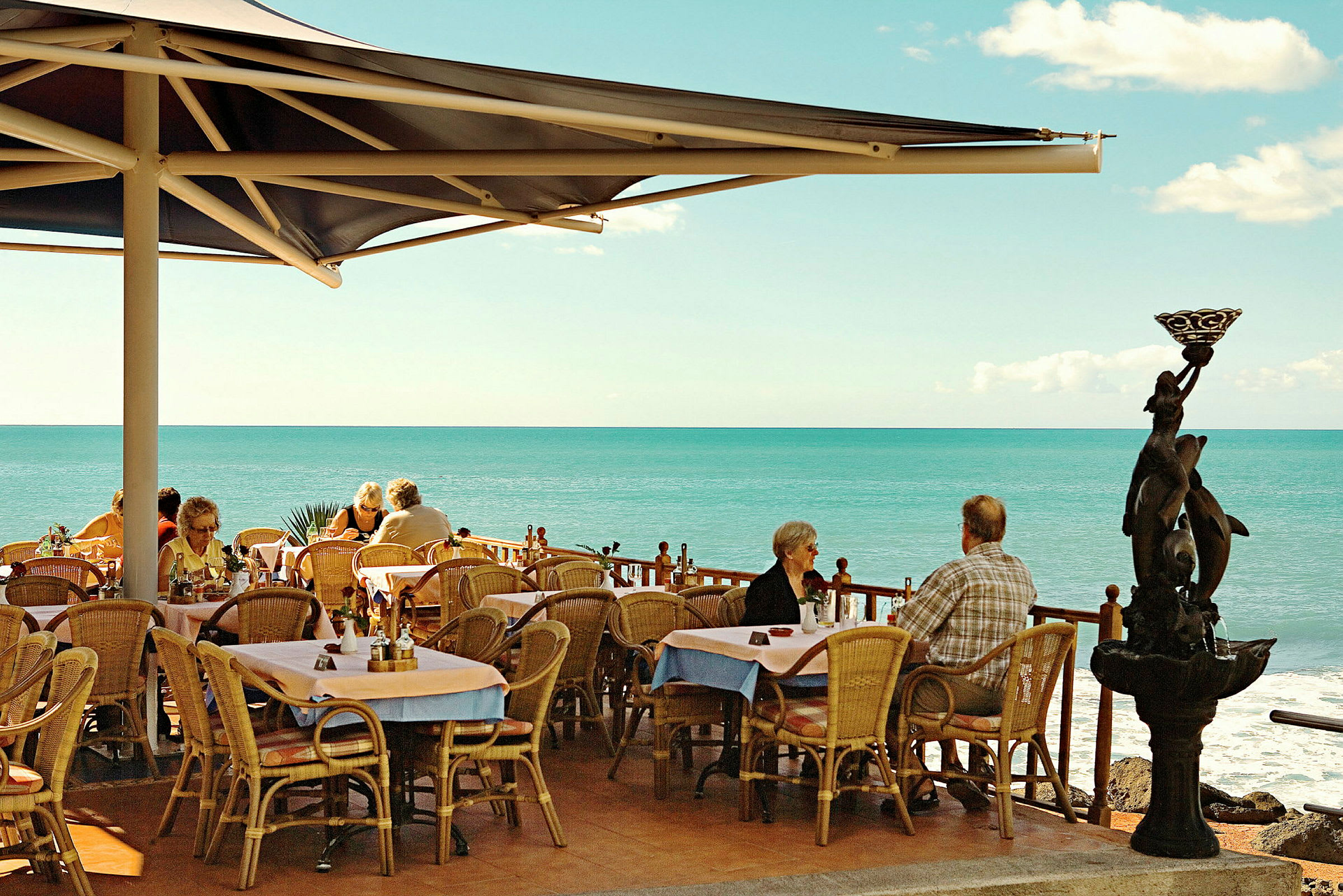 Udendørs restaurant med udsigt over havet. (AI-genereret tekst)