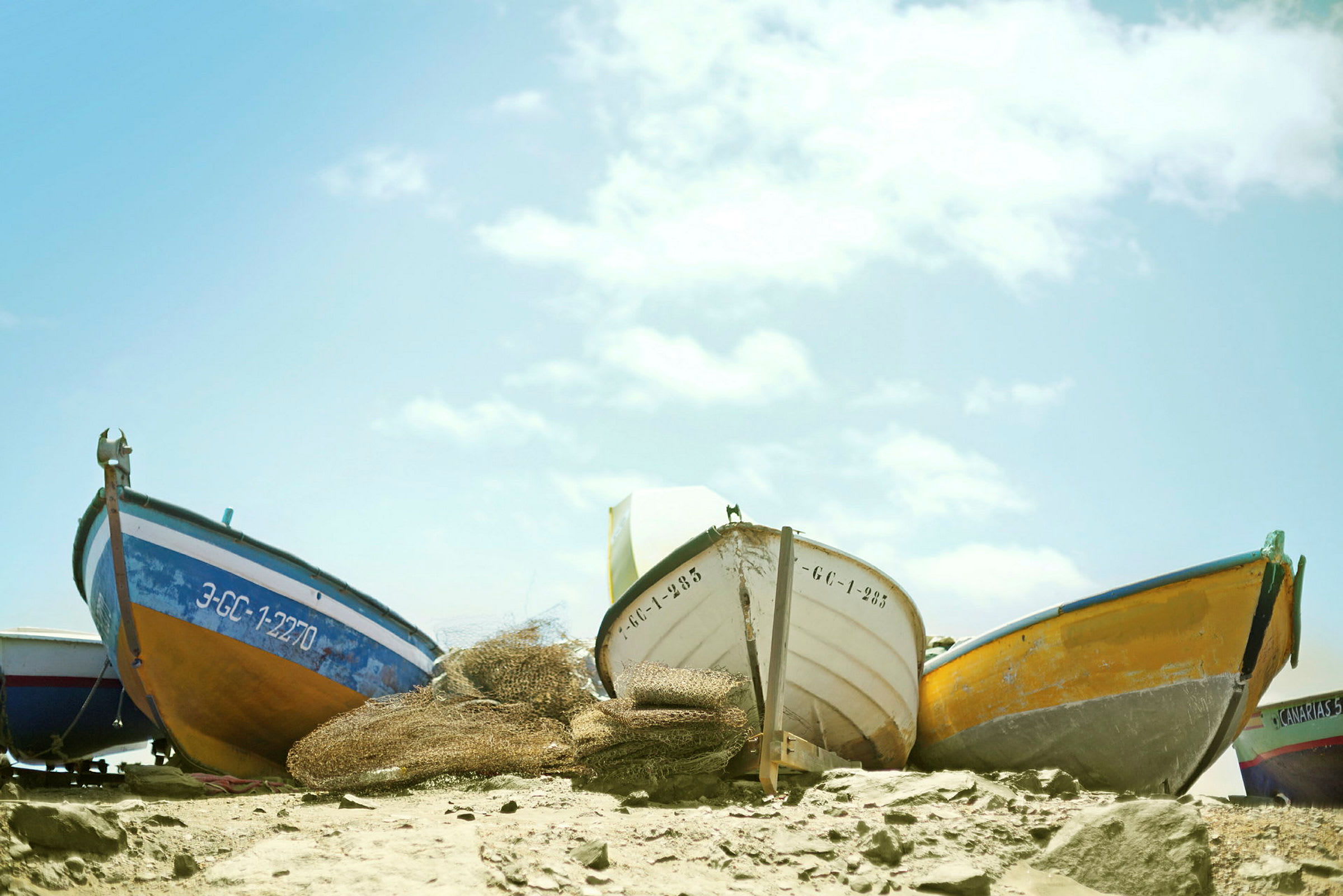 Flere små både er opstillet på en strand. (AI-genereret tekst)