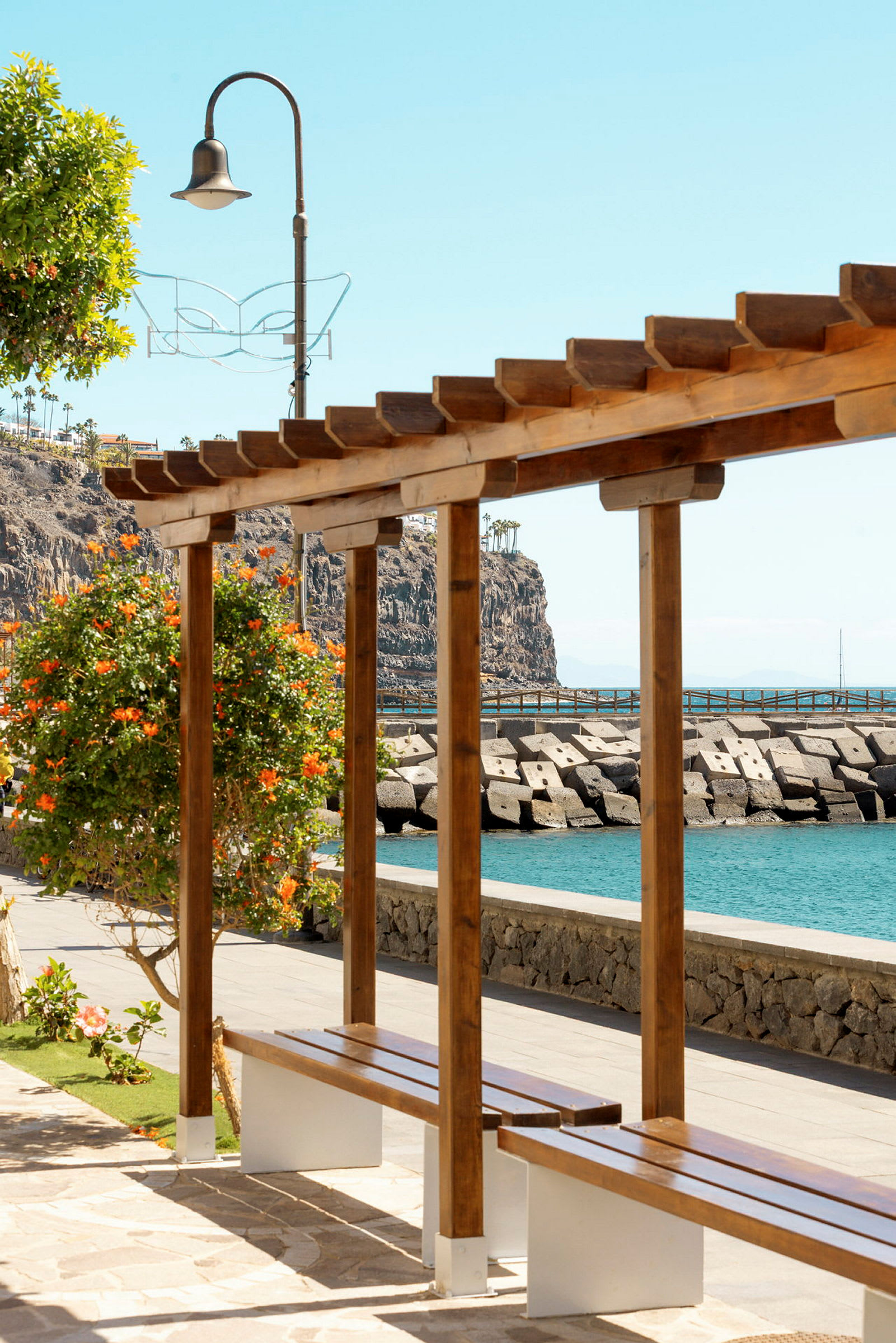Træpergola med bænk ved havet. (AI-genereret tekst)