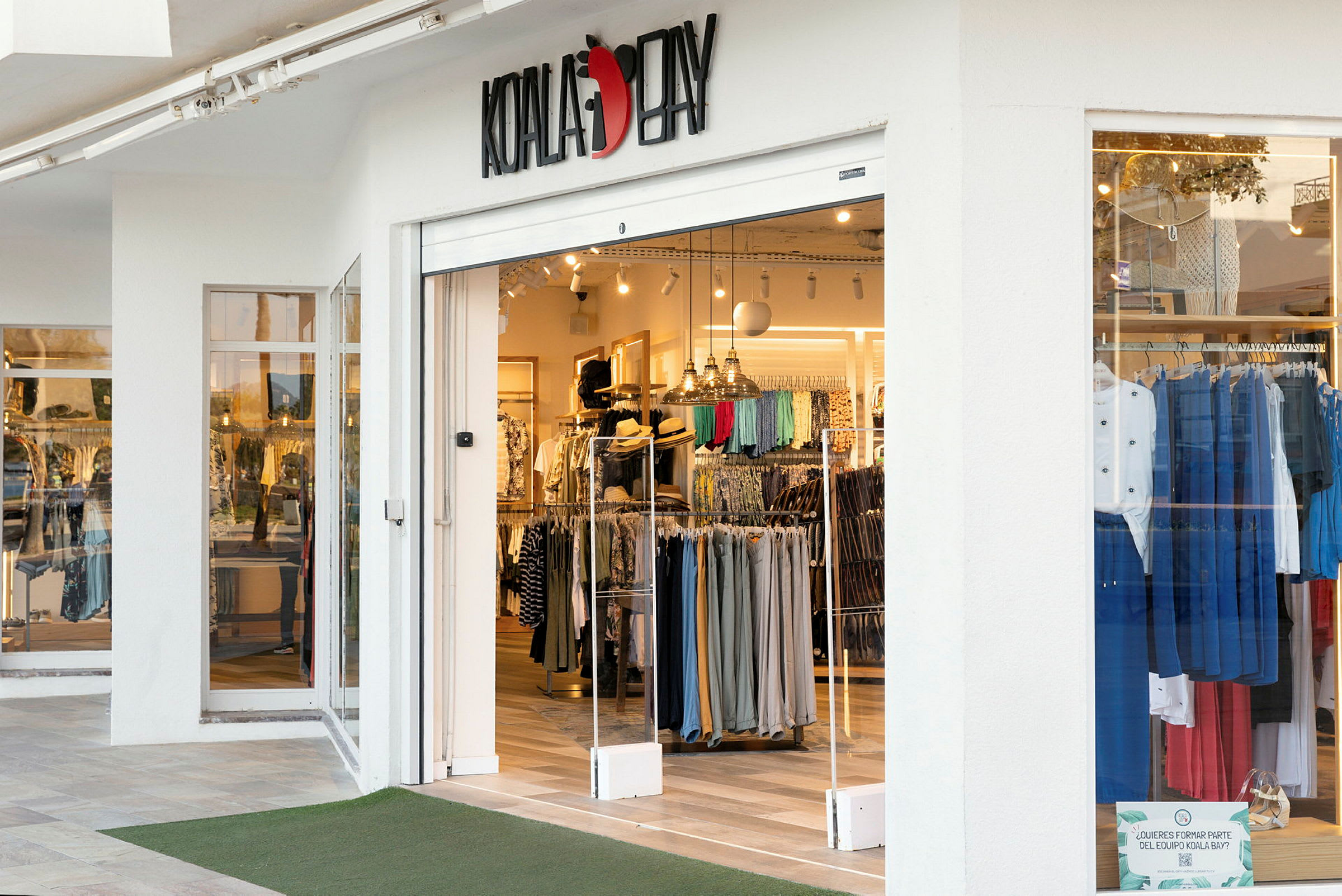 Indgang til en tøjbutik med skiltet Koala Bay. (AI-genereret tekst)