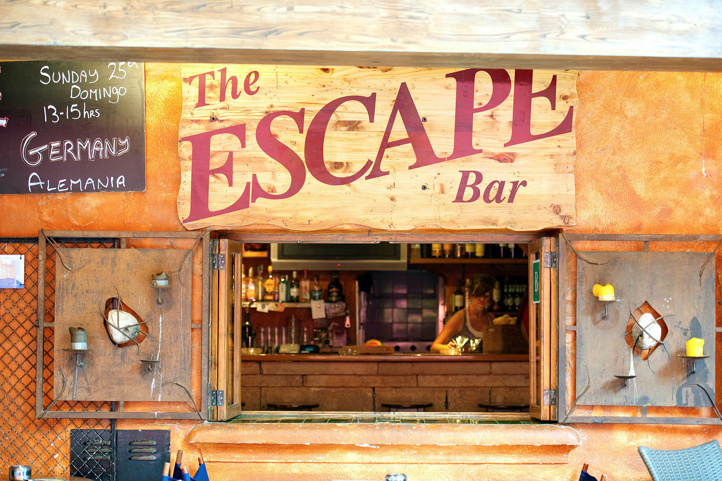 En bar med navnet 'The Escape' vises, inklusive et skilt med tekst og en åbning til baren. (AI-genereret tekst)