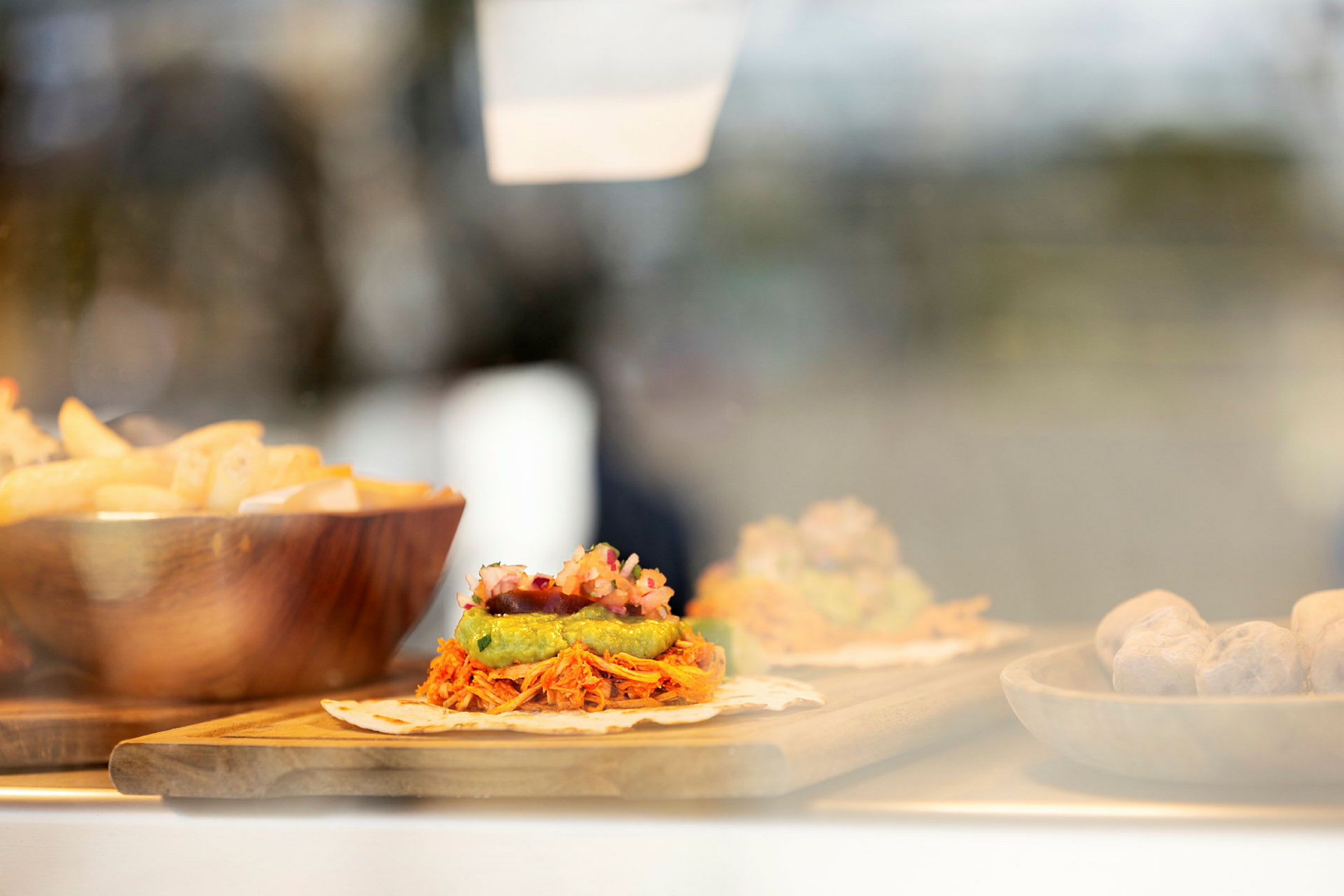 Mad bestående af tortilla med toppings, pommes frites i en skål og andre tilbehør. (AI-genereret tekst)