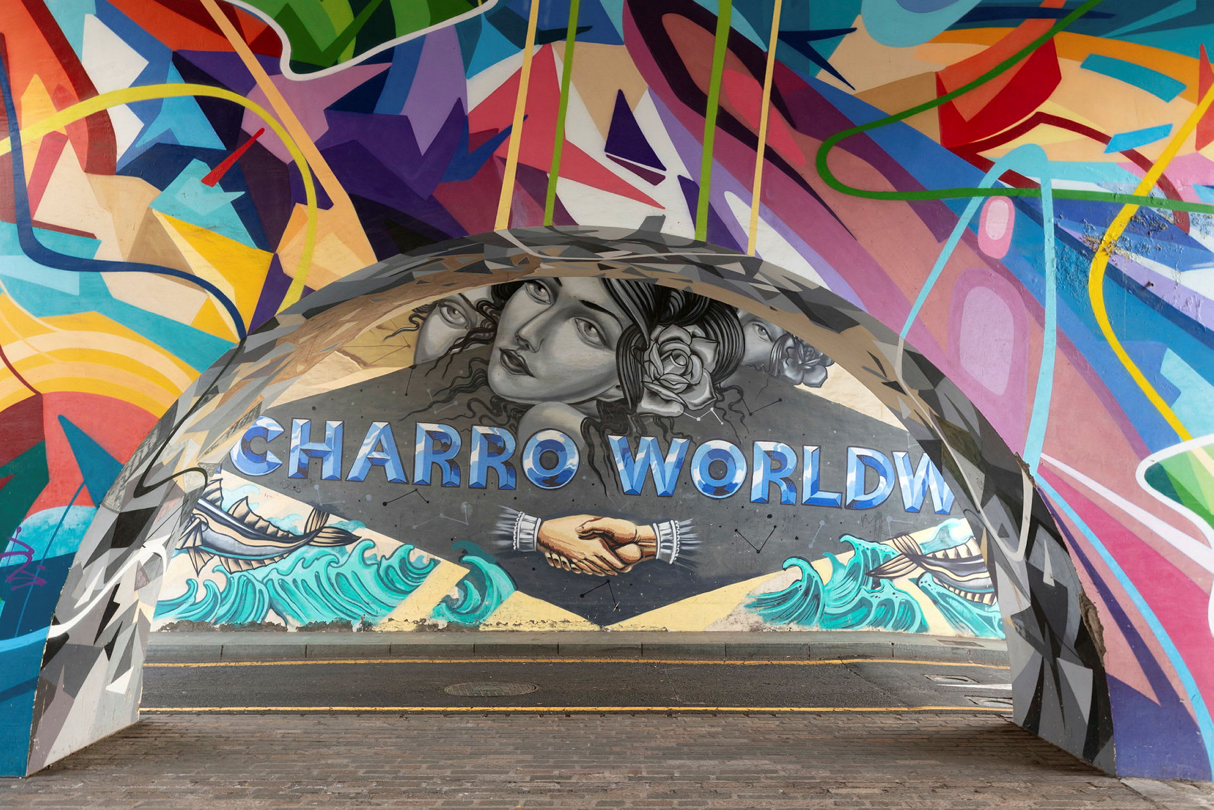 Et farverigt vægmaleri med teksten 'Charro World', håndtryk og strandmotiv. (AI-genereret tekst)