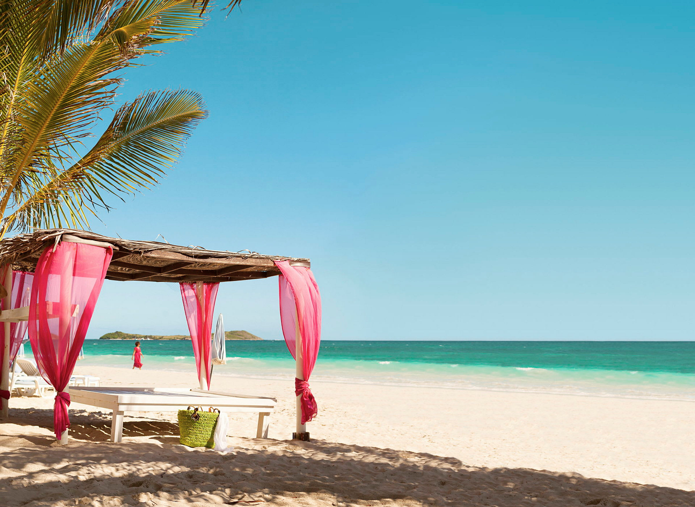 Strand med parasol og rosa stof med en fremtrædende palme. (AI-genereret tekst)