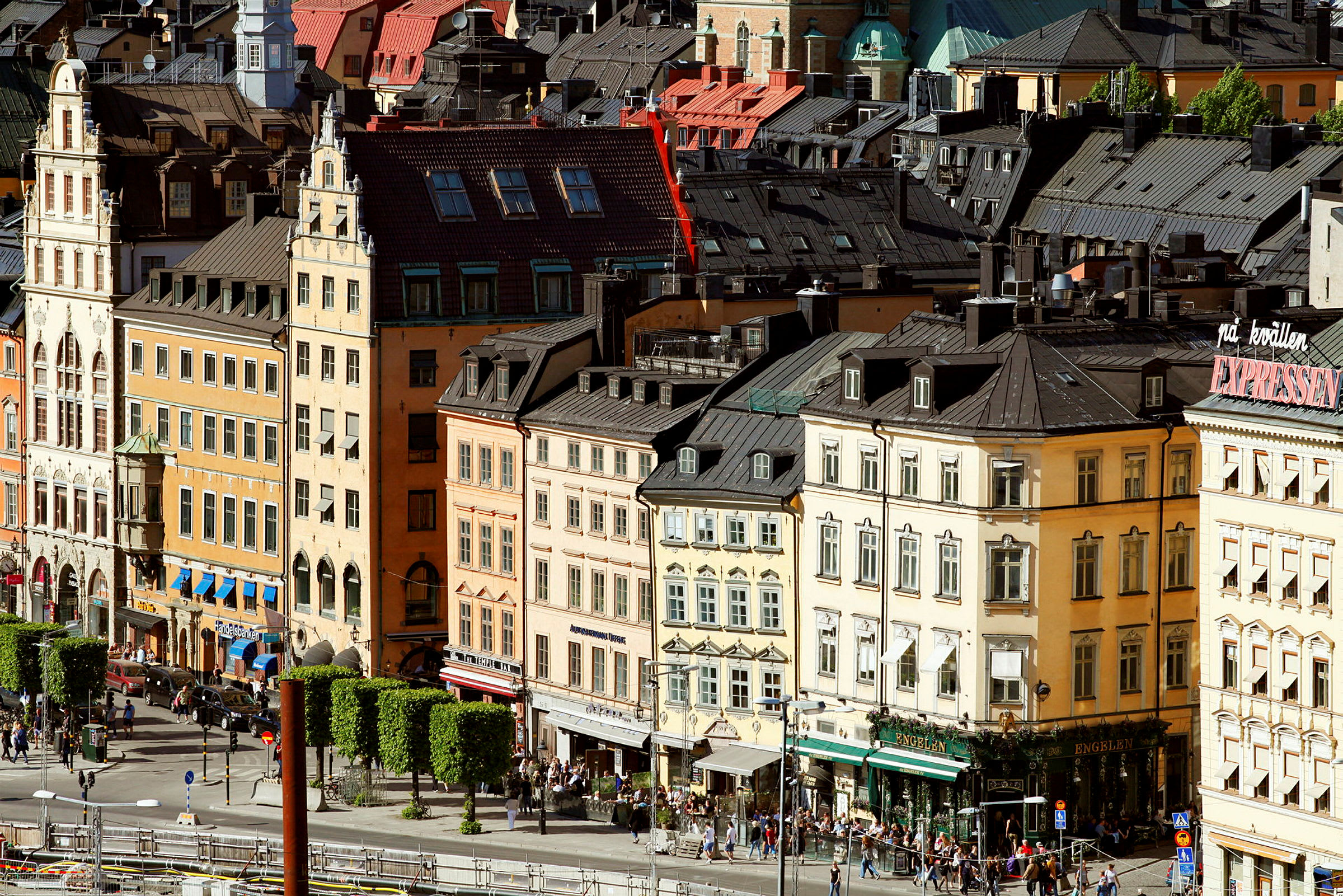 Flere farverige bygninger med ældre arkitektur i bymiljø. (AI-genereret tekst)