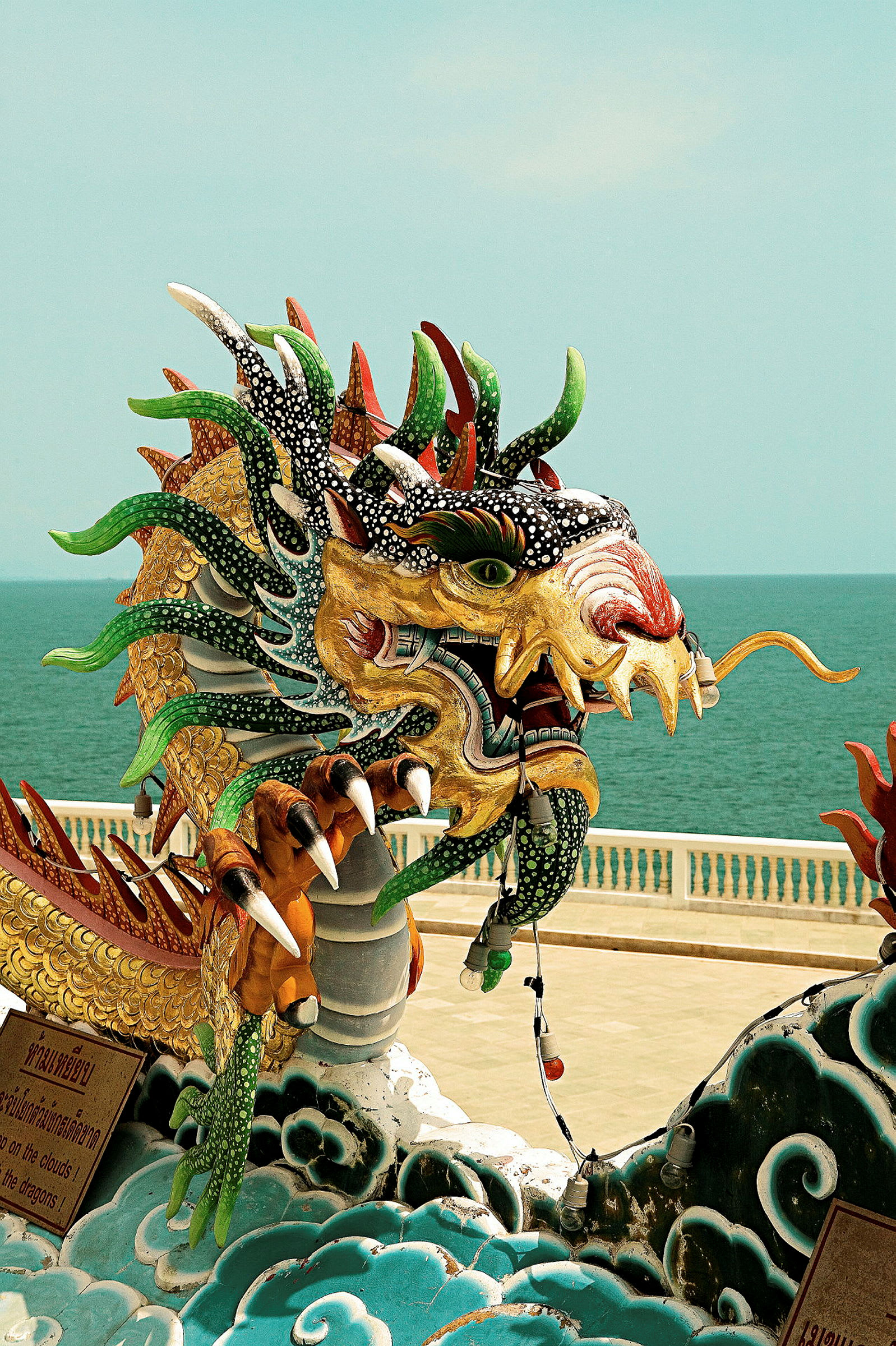 Farverig drage-statue ved en strandpromenade. (AI-genereret tekst)