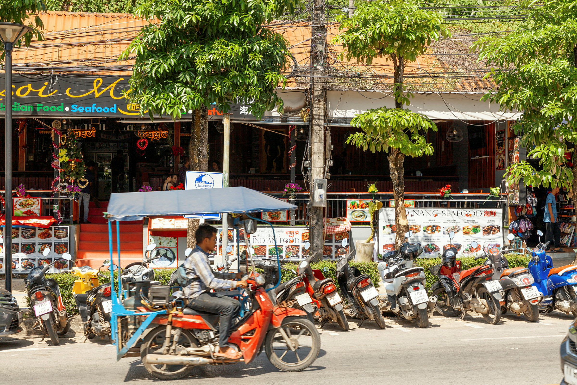 Et gademiljø med motorcykler parkeret foran en restaurant. (AI-genereret tekst)