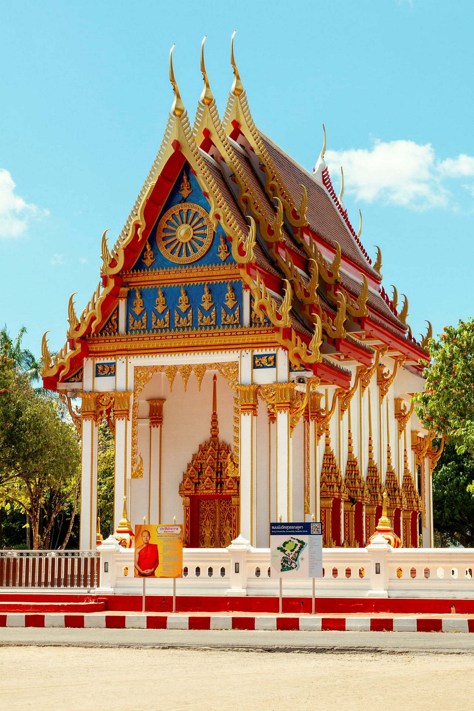 Rigt dekoreret buddhistisk tempelbygning med ornamenteret facade og spids tag. Solrigt vejr. (AI-genereret tekst)