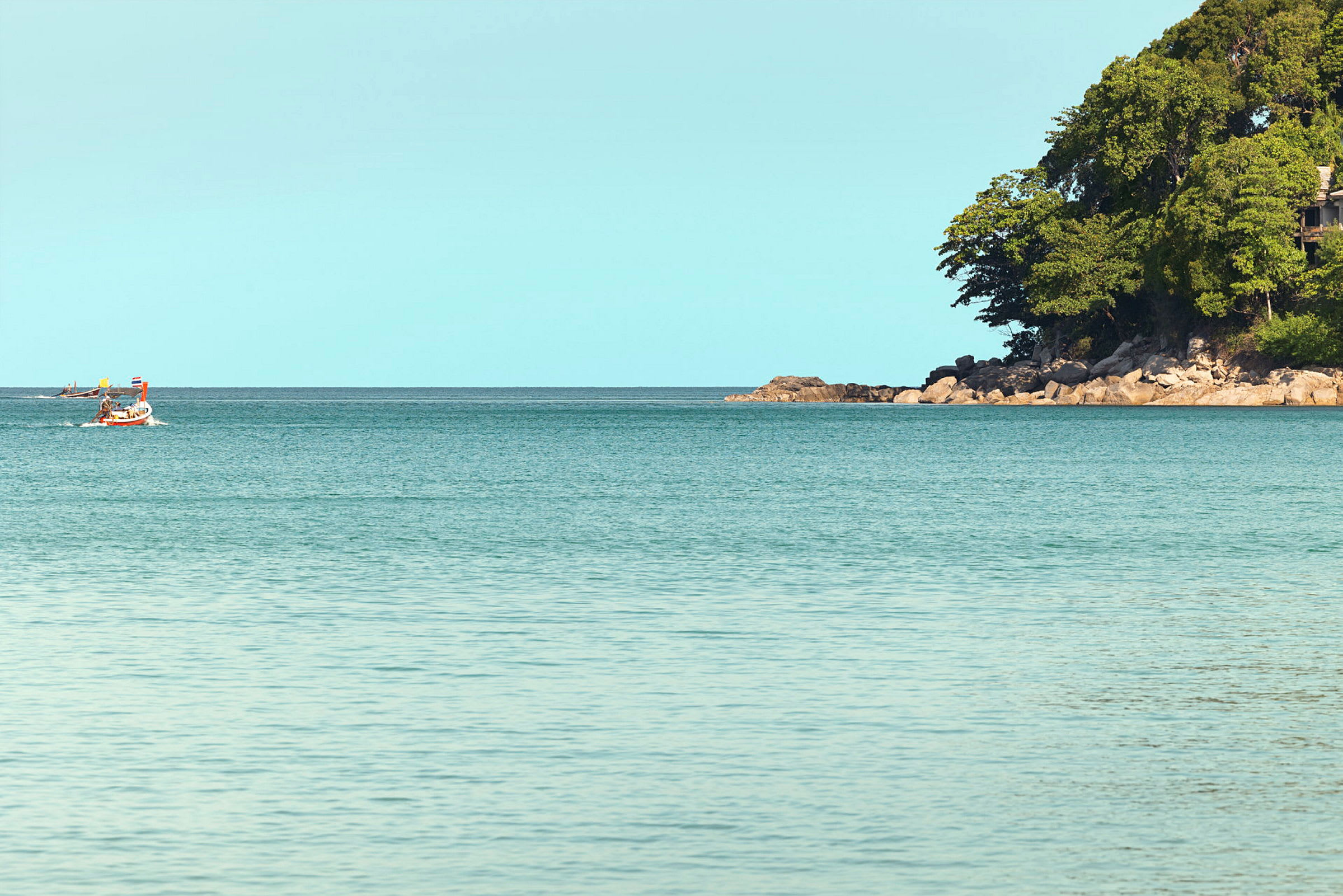 En båd på havet med en skovklædt odde i baggrunden. (AI-genereret tekst)