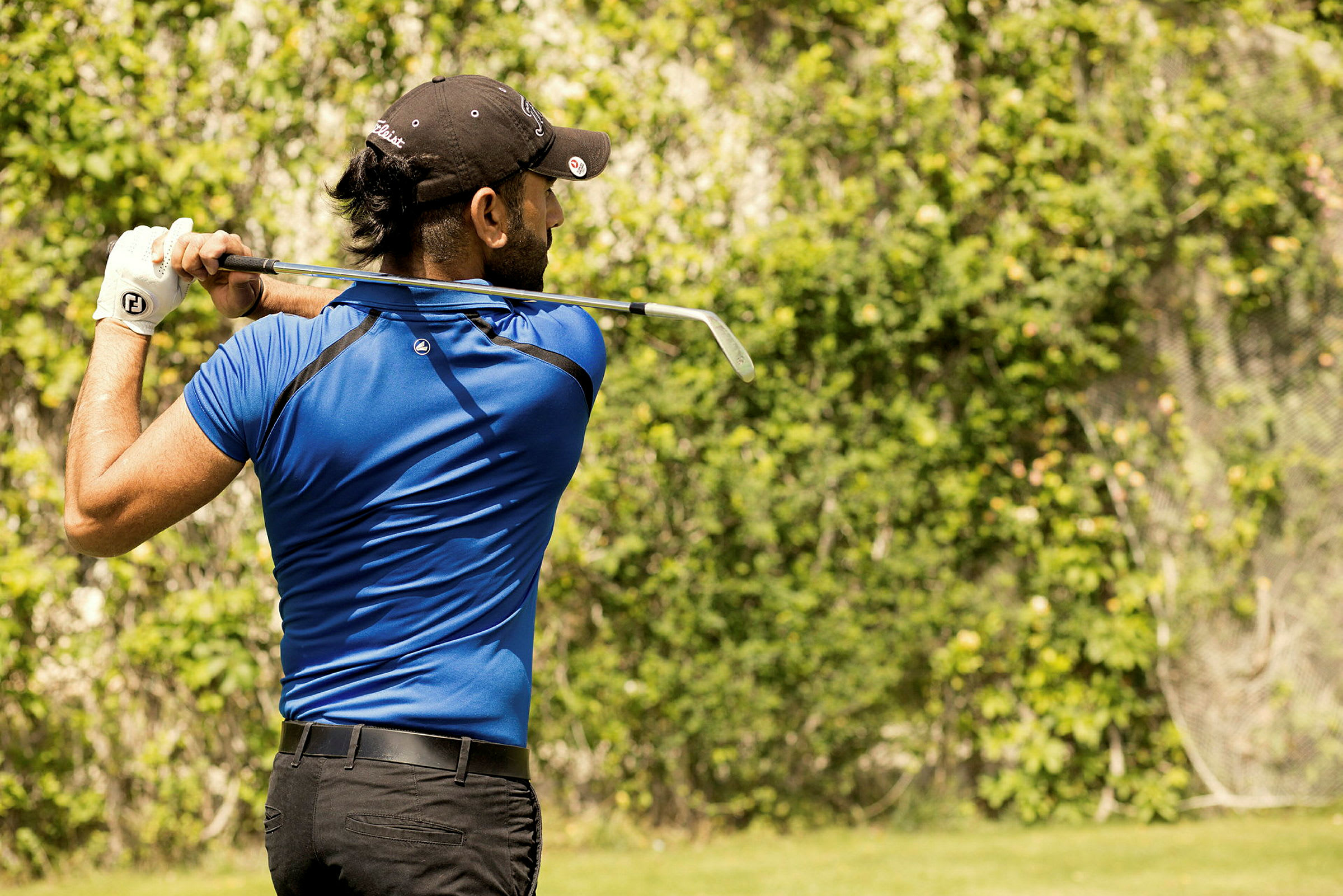 En person, der spiller golf på en grøn plads. (AI-genereret tekst)
