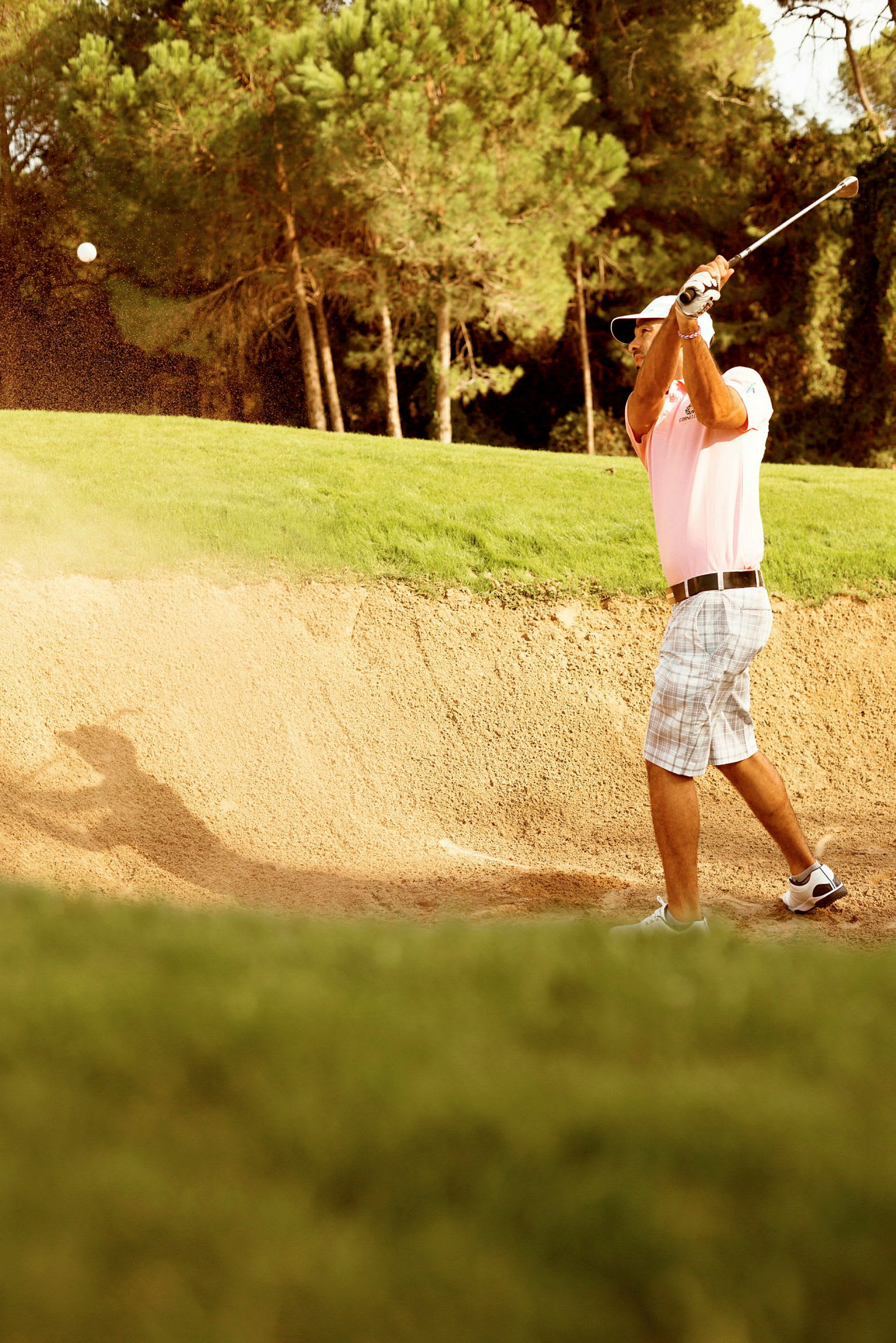Person spiller golf fra en sandbunker. (AI-genereret tekst)