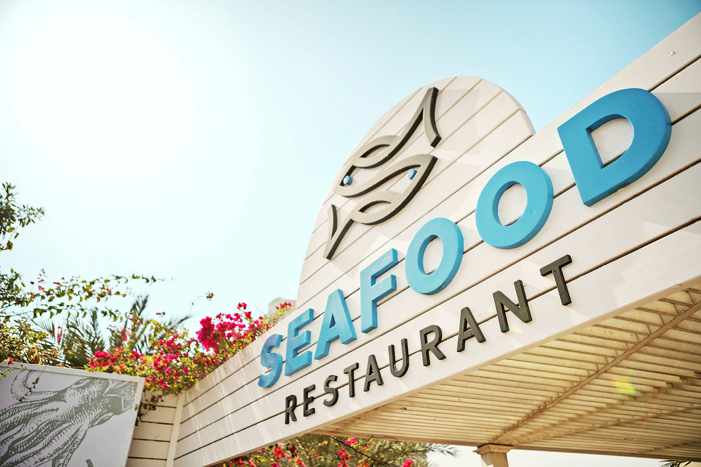 Skilt til en restaurant med teksten Seafood. (AI-genereret tekst)