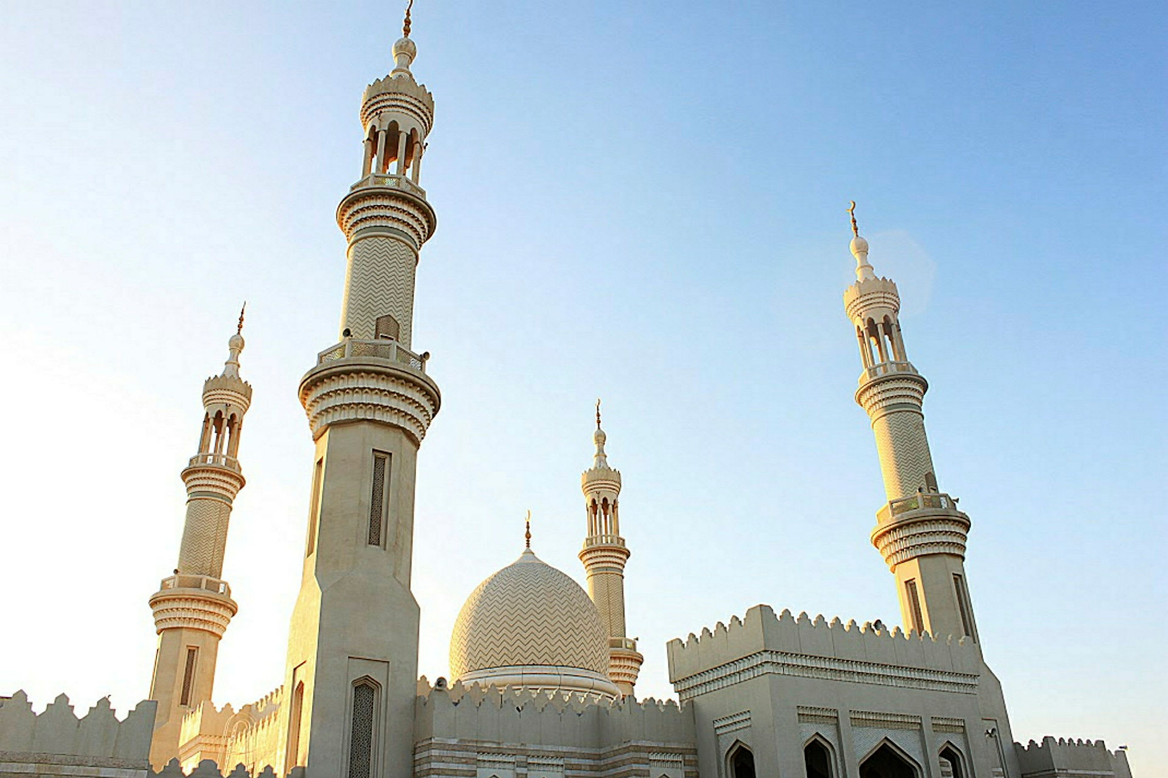 En moské med flere minareter mod en klar himmel. (AI-genereret tekst)