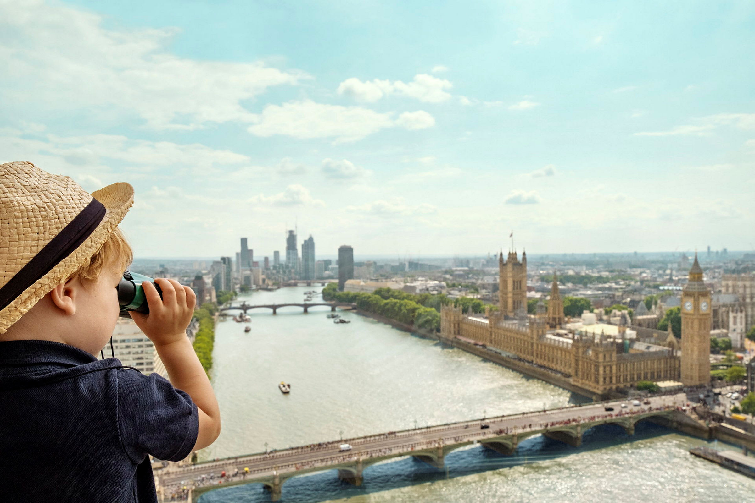 Barn med hat kigger gennem en kikkert over London med Houses of Parliament og Themsen. (AI-genereret tekst)
