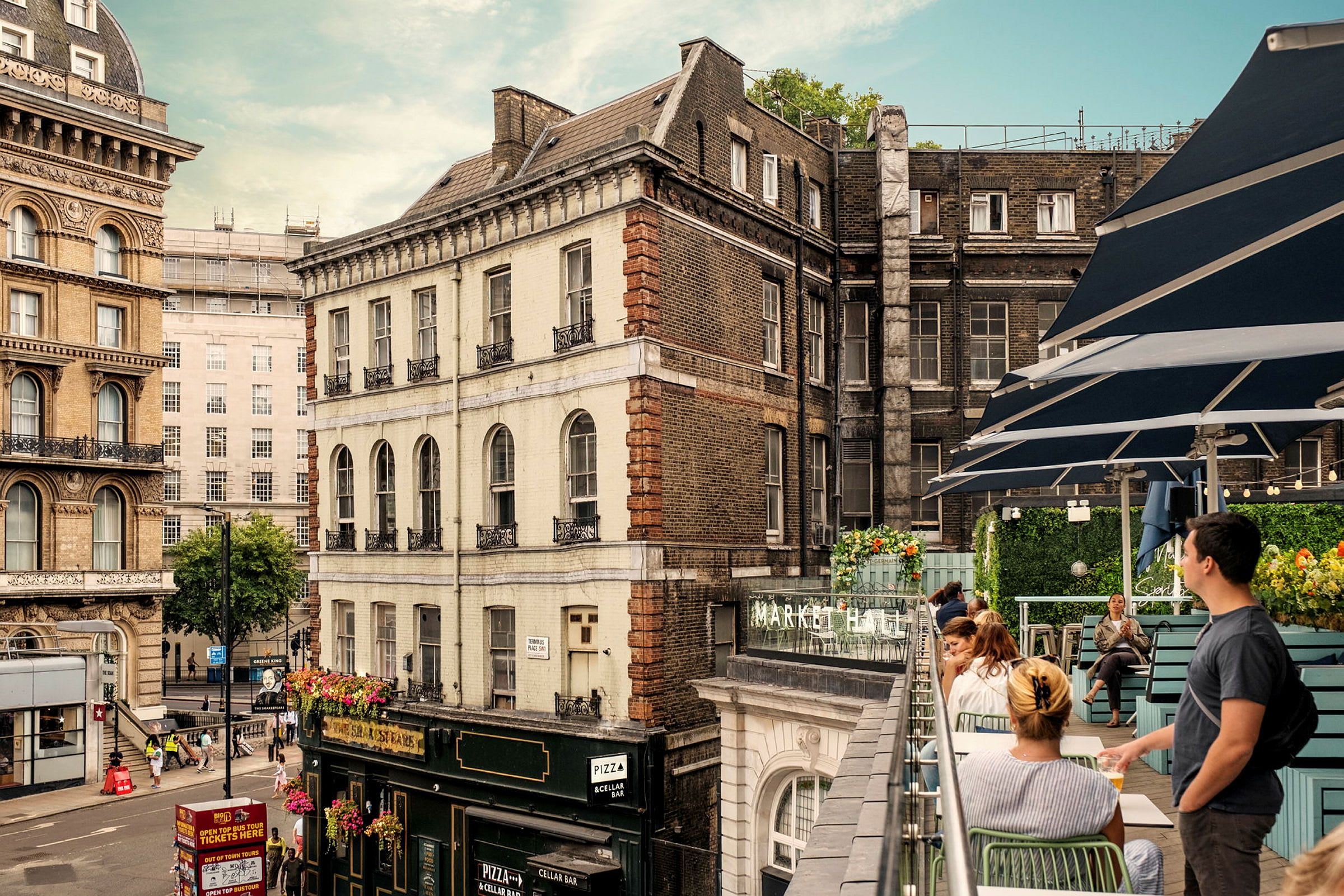Udsigt over et bymiljø med historiske bygninger og en terrasse med siddepladser. (AI-genereret tekst)