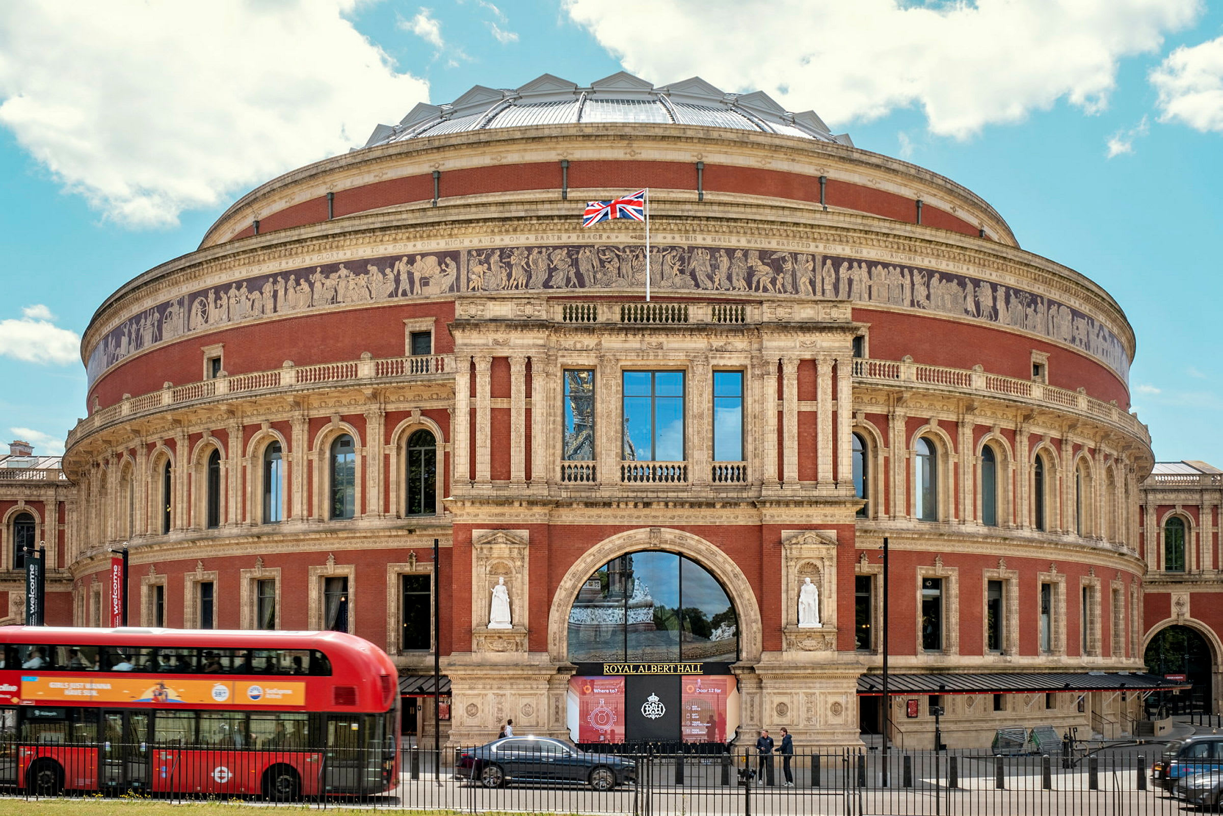 Et billede af Royal Albert Hall i London, med en rød bus i forgrunden. (AI-genereret tekst)