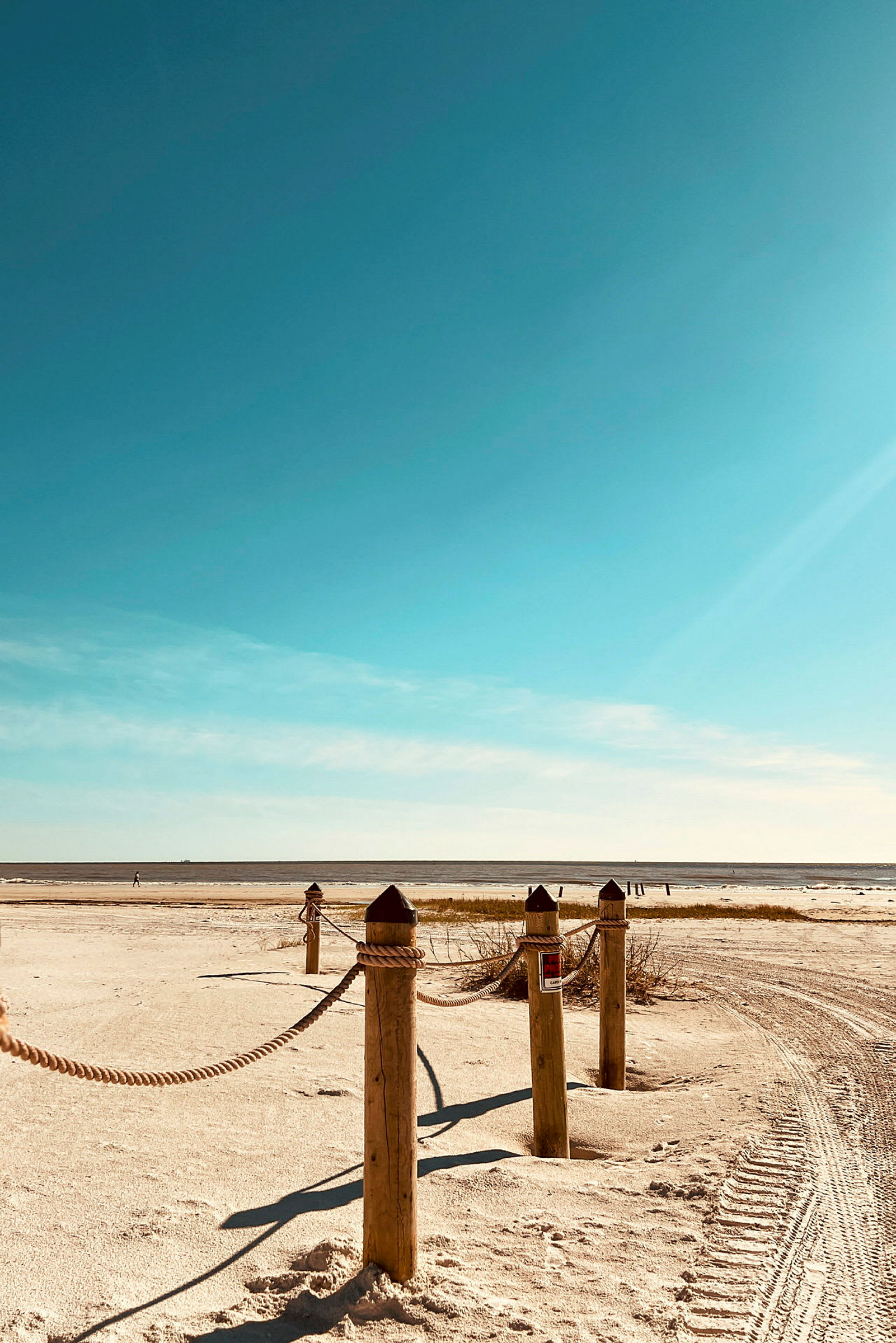 Træstolper med reb ved en strand. (AI-genereret tekst)