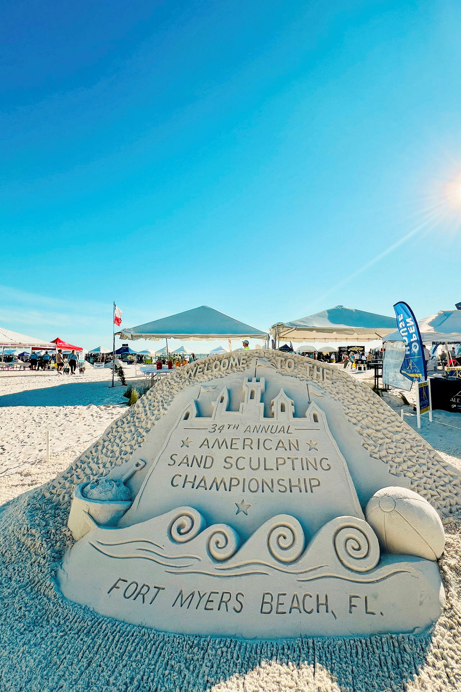 Sandstatue med teksten 'Fort Myers Beach, FL' og 'American Sand Sculpting Championship'. (AI-genereret tekst)