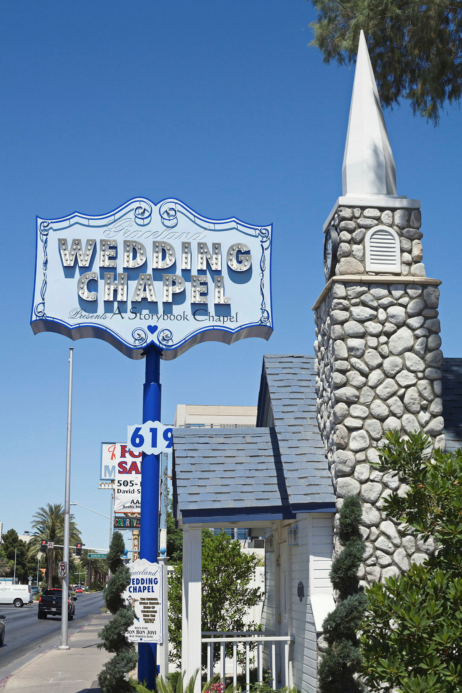 Et skilt med teksten 'Wedding Chapel' over en stenkirke bygning, med en blå himmel i baggrunden. (AI-genereret tekst)