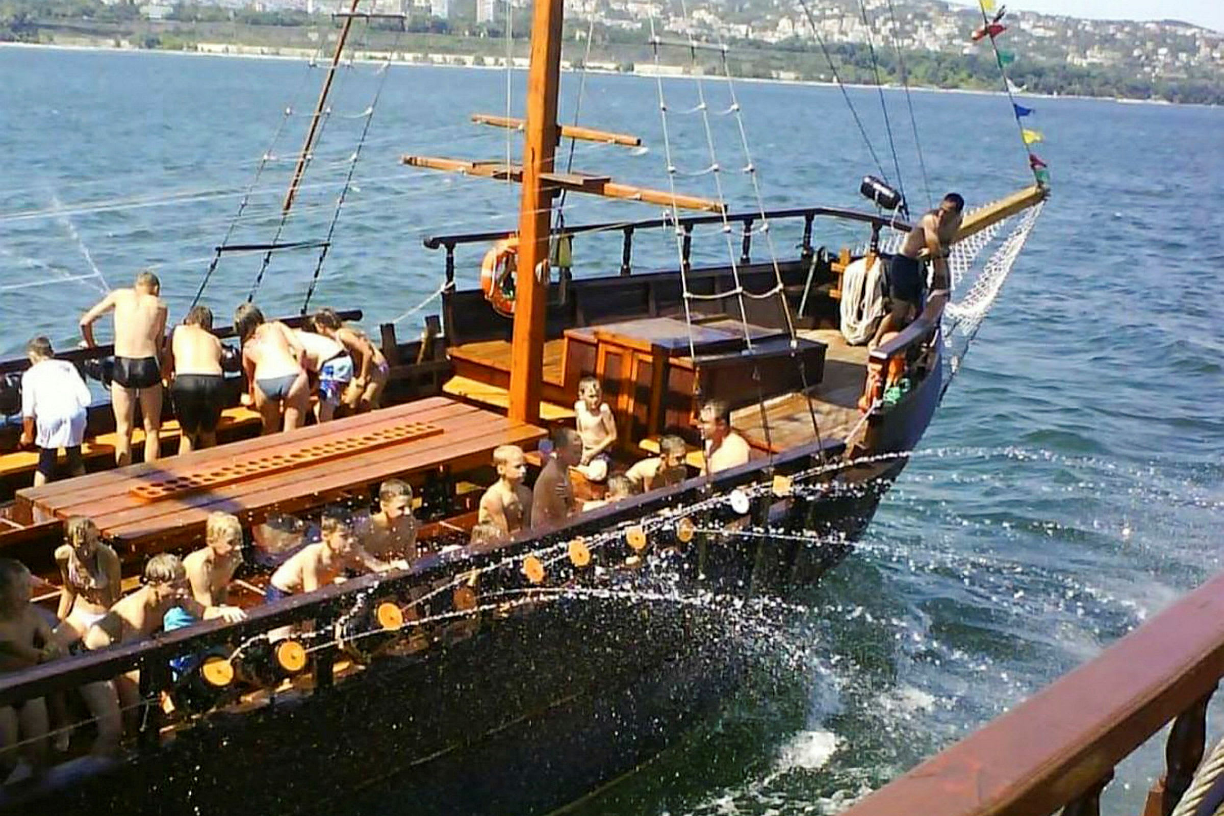 Billedet viser en båd med mennesker ombord på åbent vand. (AI-genereret tekst)