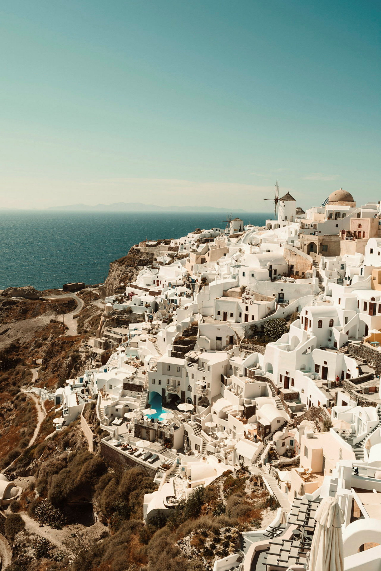 Udsigt over hvide huse og bygninger på en klippe ved havet, typisk for Santorini. (AI-genereret tekst)