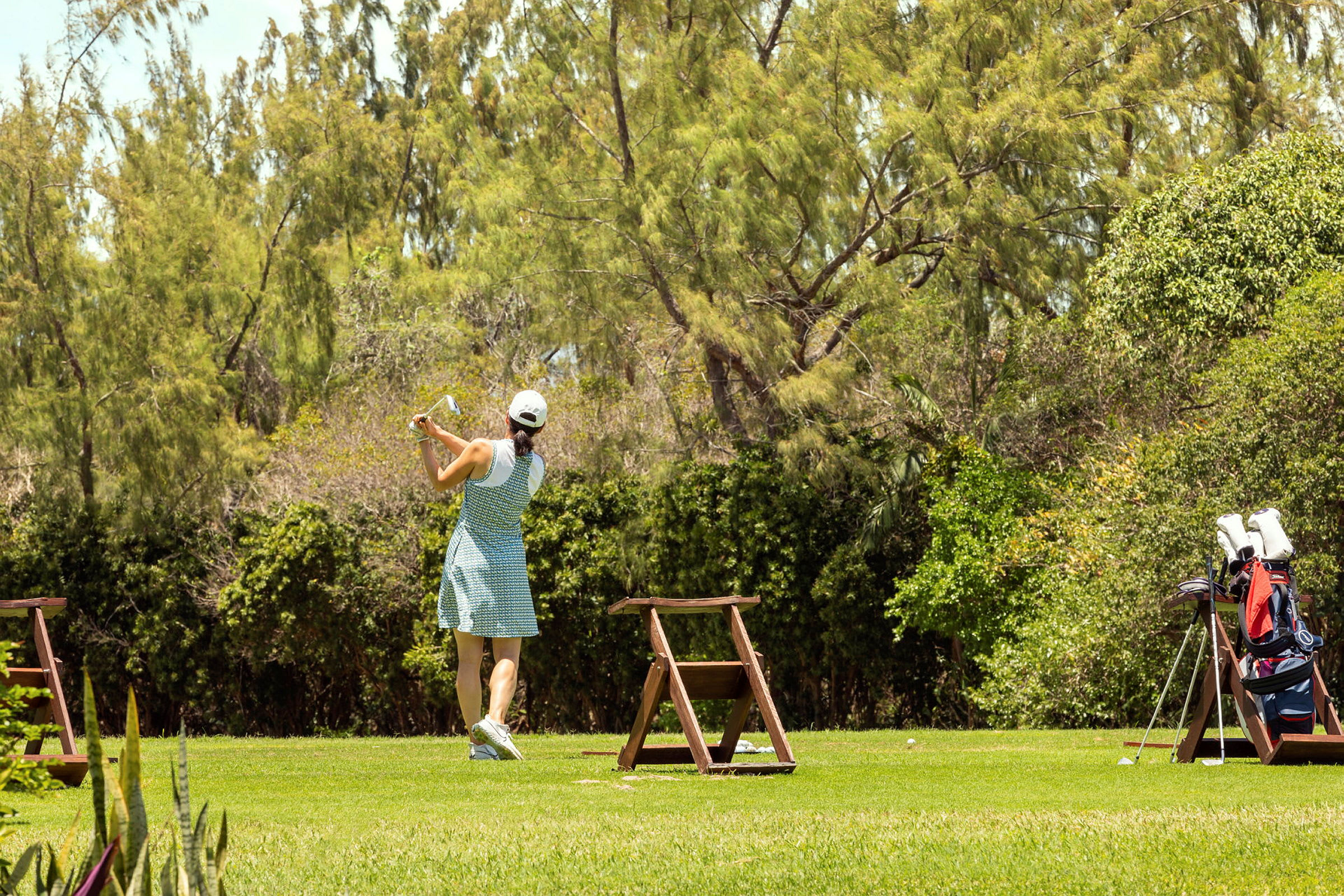 En person, der spiller golf på et grønt område. (AI-genereret tekst)