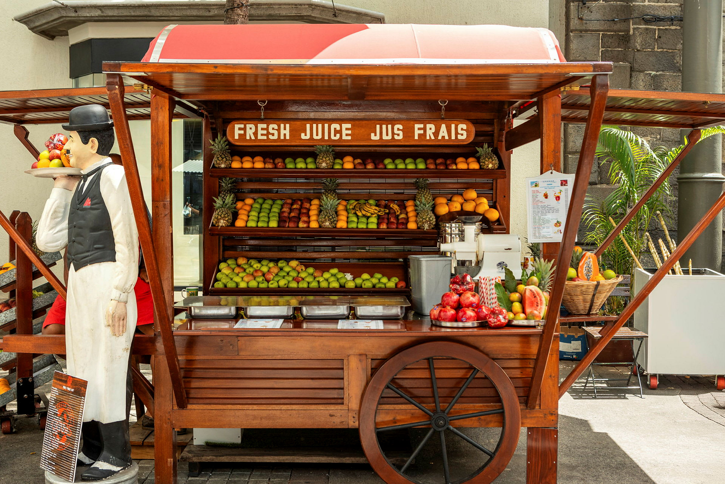 En frugtbod med friske frugter og en juicepresser. (AI-genereret tekst)