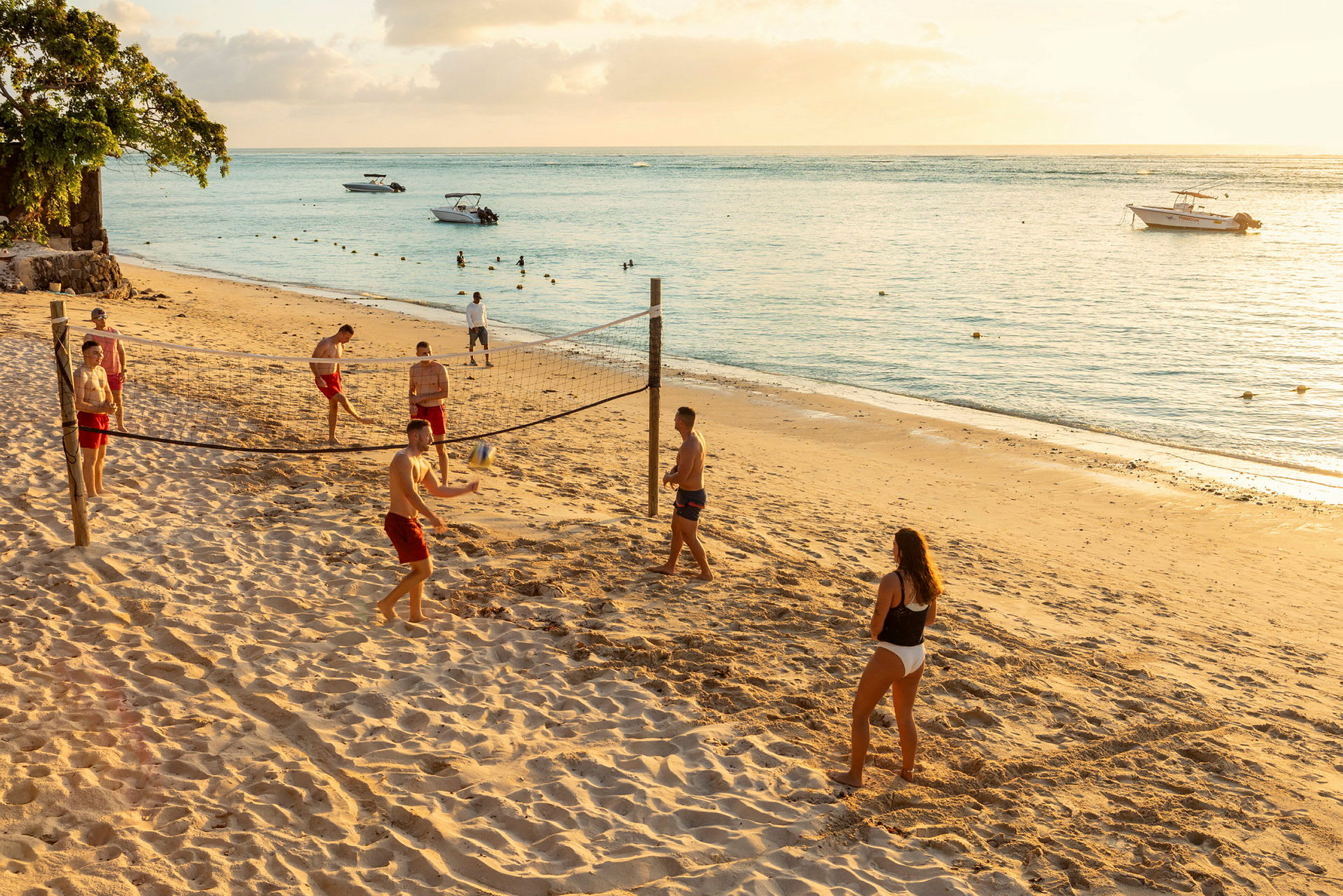 Personer spiller volleyball på en sandstrand ved havet. (AI-genereret tekst)