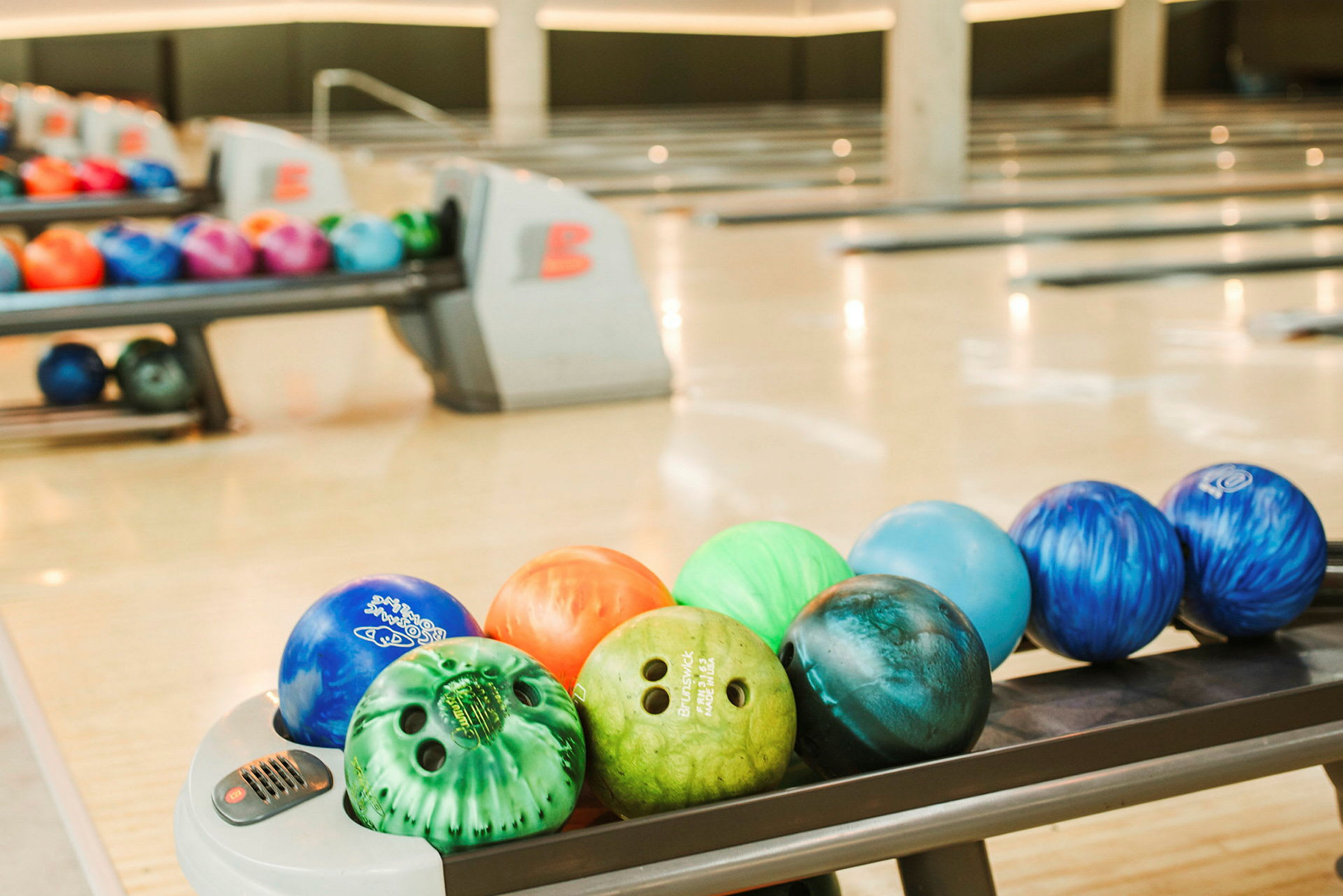 Bowlingkugler i forskellige farver på banerne i en bowlinghal. (AI-genereret tekst)