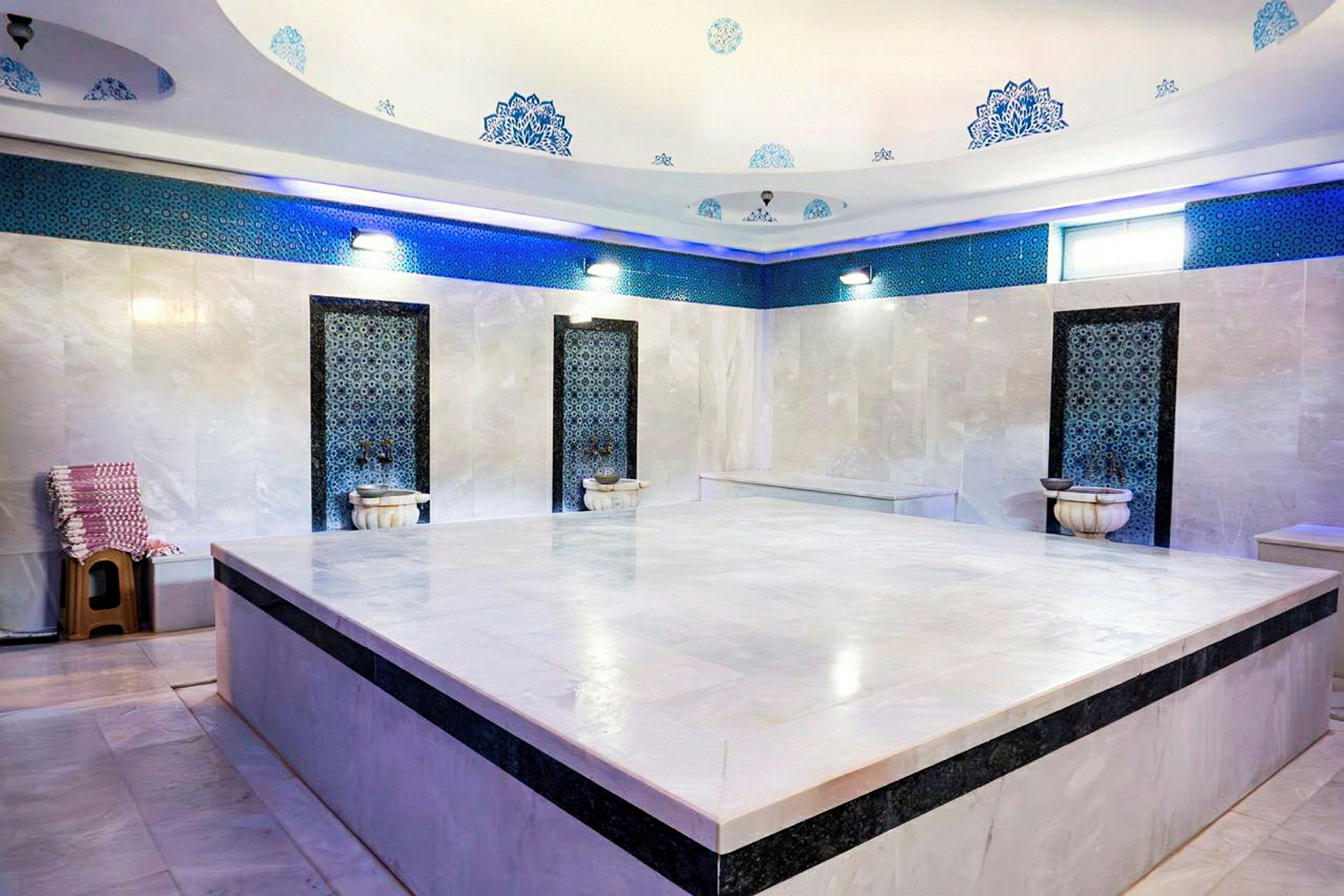 Et traditionelt tyrkisk hamam med marmorerede vægge, dekorative detaljer og en stor central platform. (AI-genereret tekst)