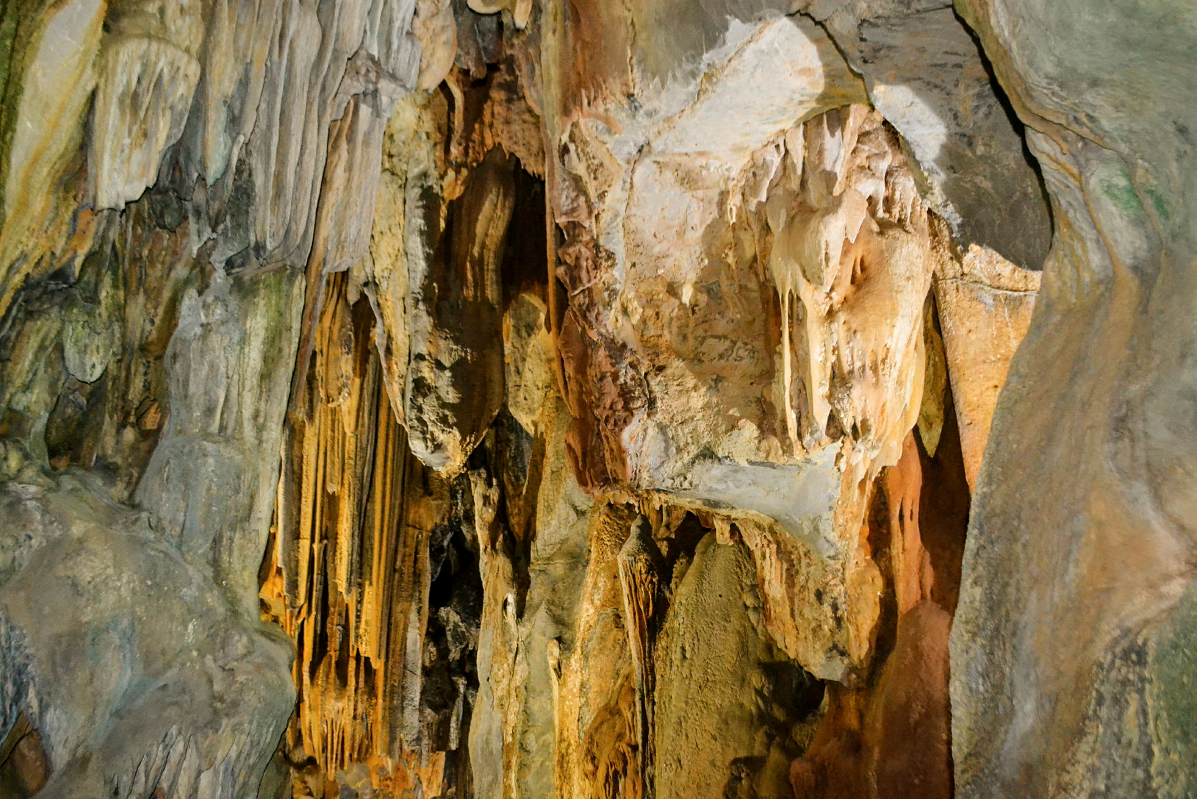Billede af en grotte med stalaktitter og stalagmitter på væggene. (AI-genereret tekst)