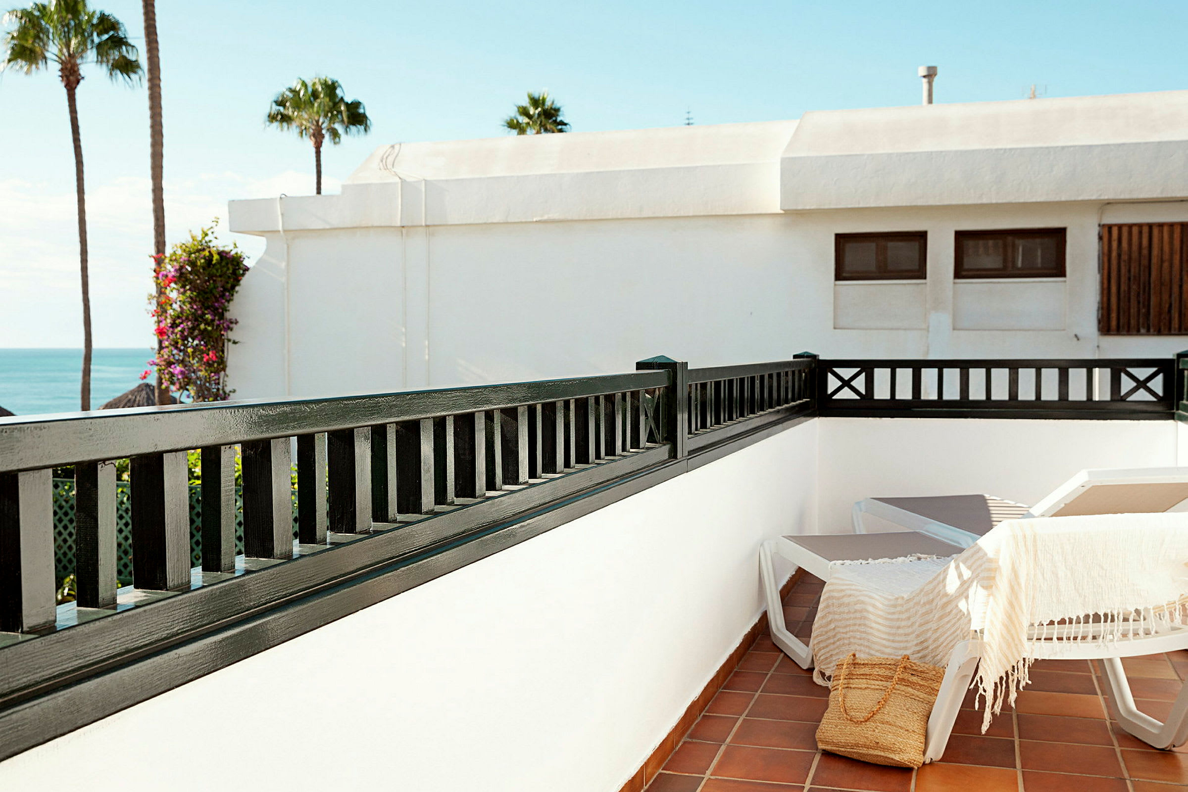 Solterrasse med stole og udsigt til havet. (AI-genereret tekst)